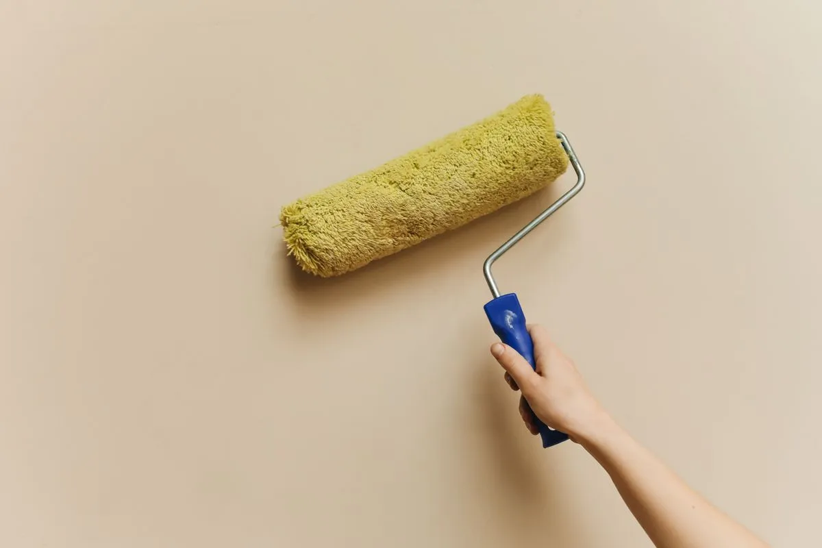 Paint roller applying a fresh coat to a wall